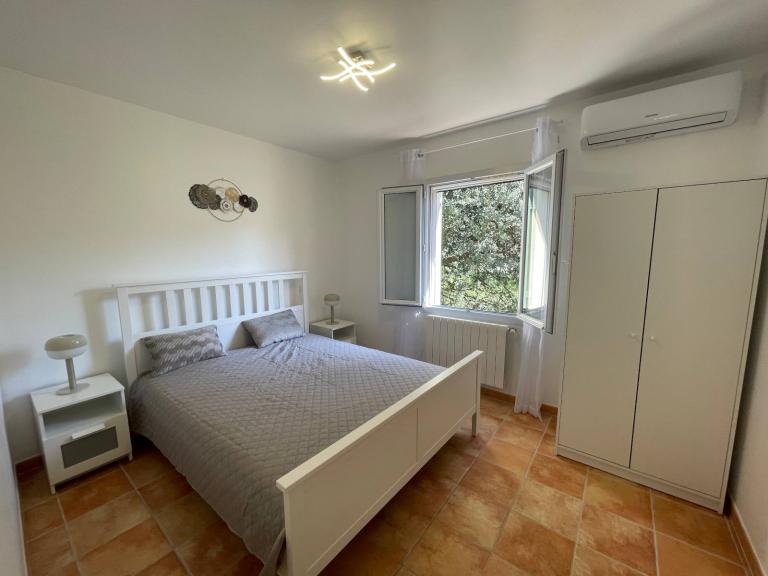 Chambre du gîte l'Olivier d'Alana avec vue sur l'arrière du jardin et la nature.