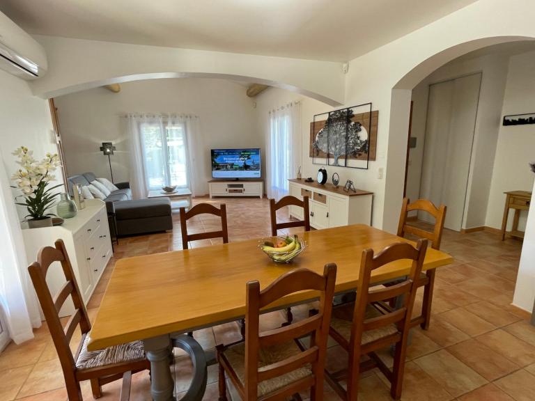 Salon et séjour donnant directement sur la grande terrasse extérieure et vers la piscine, le sauna et le poolhouse